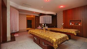 A hotel room with two beds, a large mirror, and a chandelier.