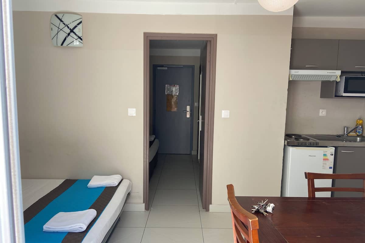 Una habitación de hotel con cama, kitchenette y zona de comedor.