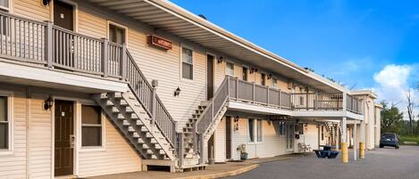 A row of motel buildings with balconies and a parking lot.