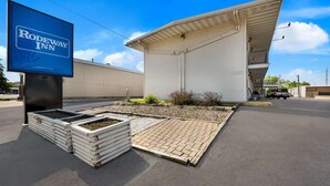 A Rodeway Inn with a large sign, a covered outdoor area, and a paved entrance. - Rodeway Inn La Crosse (La Crosse)