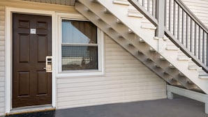 A residential building with a brown front door, a window, and a staircase leading to the upper floor. - Rodeway Inn La Crosse (La Crosse)