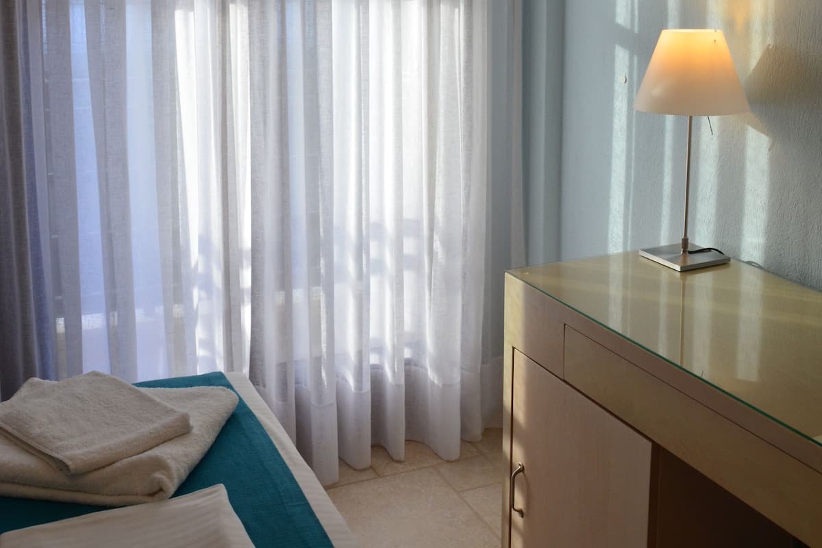 Ein Hotelzimmer mit einem Bett, einem Schreibtisch und einer Lampe.