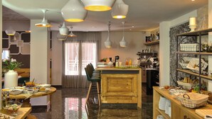 A modern dining area with a central island, bar seating, and a variety of food and drink options. - Elia Daliani (Chania)