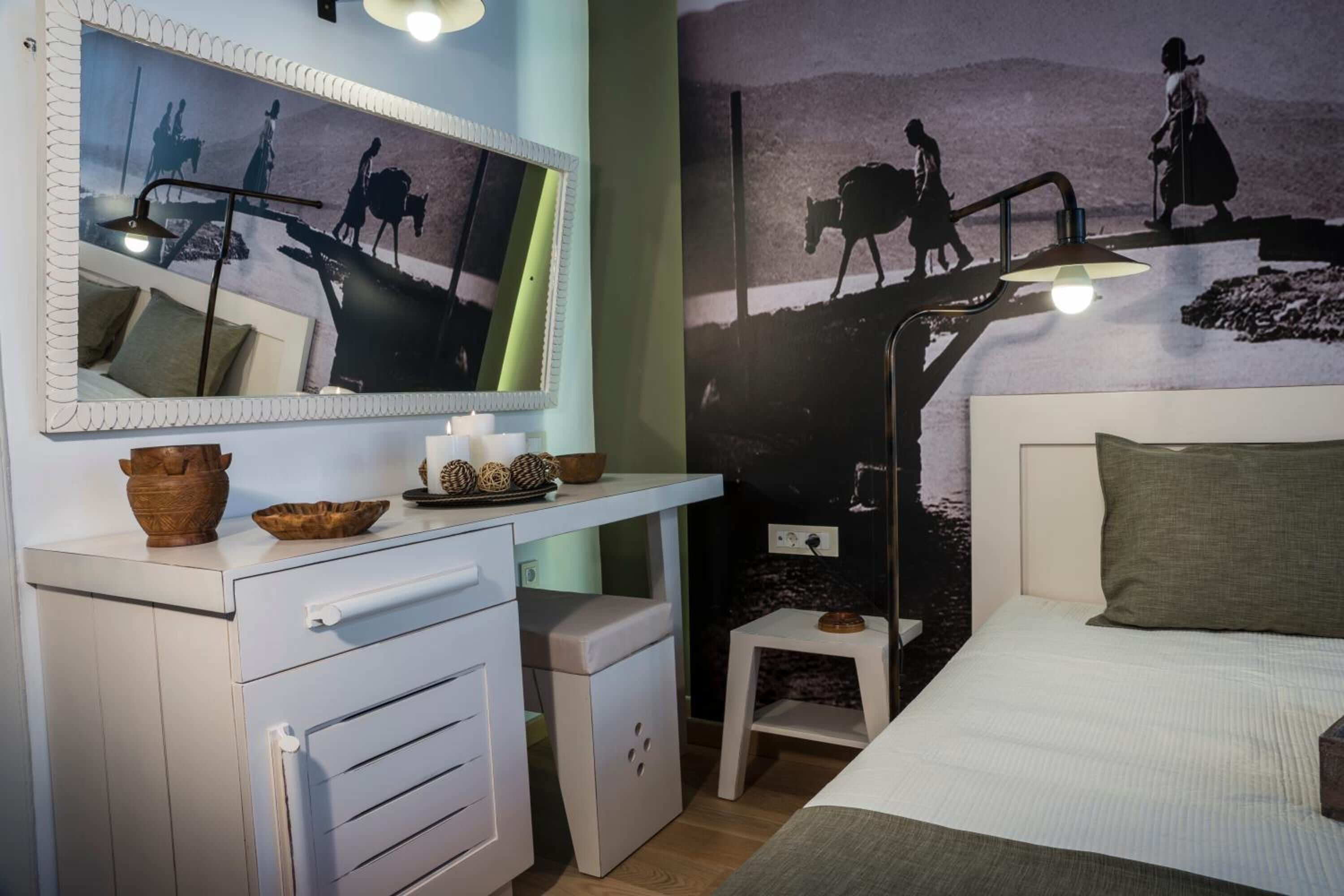 Un dormitorio con cama, cómoda, espejo y un mural en la pared.