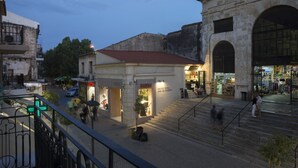 A street scene with a building featuring a storefront with a sign that reads "BLOOM." - Elia Daliani (Chania)