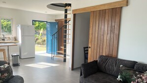 A modern living room with a sofa, a coffee table, and a staircase leading to an outdoor area. - Colombus Résidence (Oyster Pond)