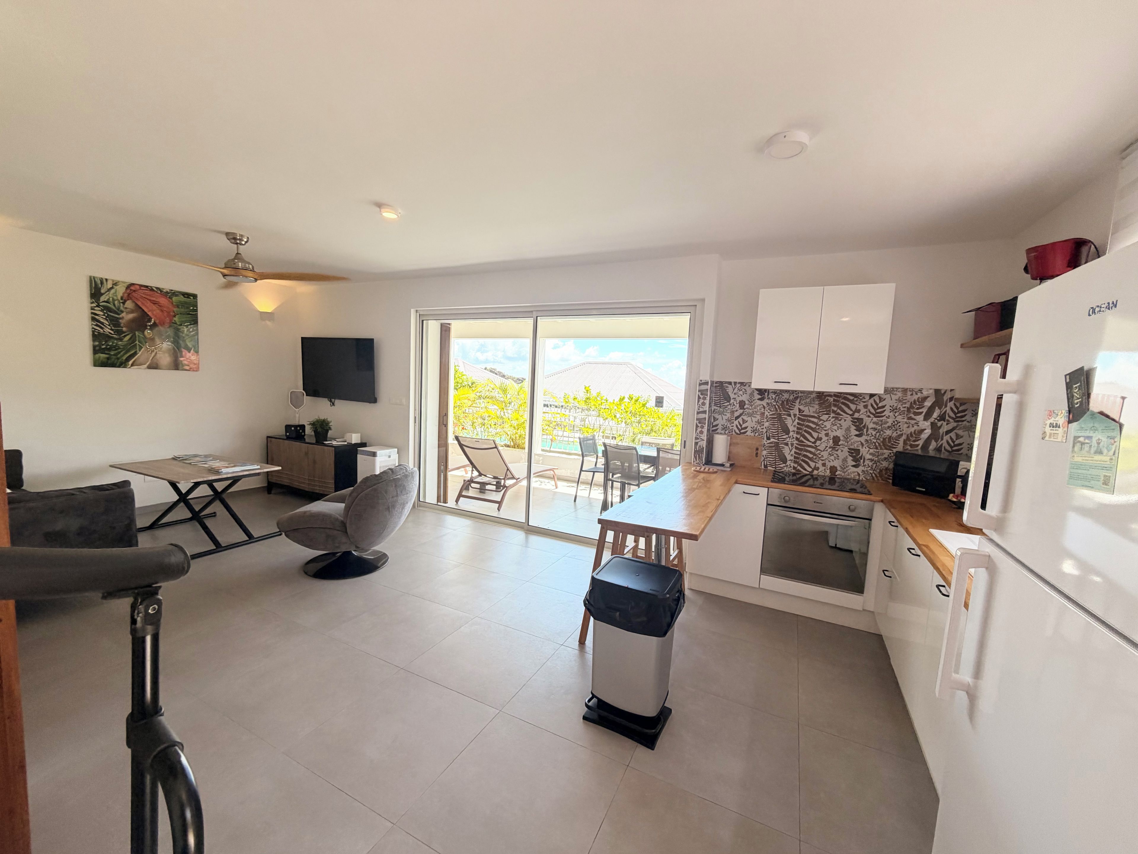 A modern kitchen with a refrigerator, stove, and dining area.