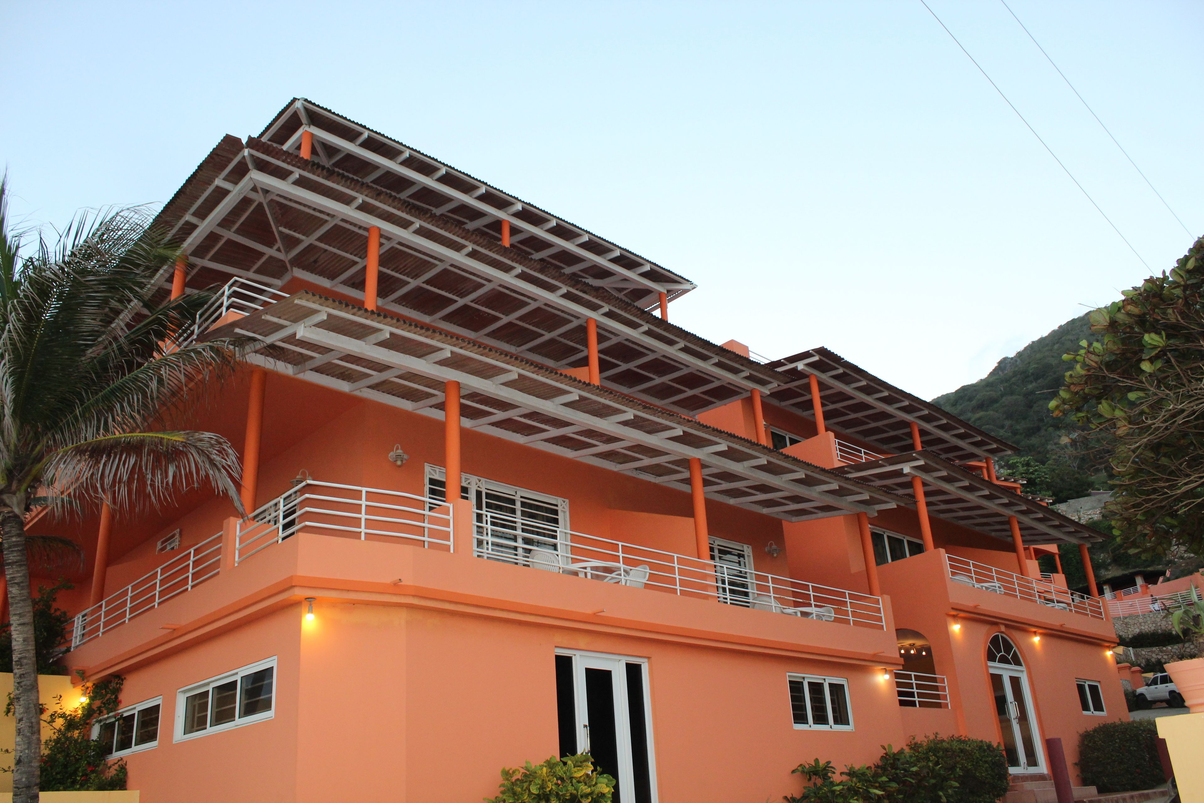 A multi-story building with balconies, a flat roof, and a door.