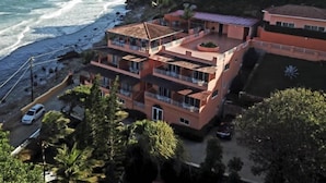 A multi-story building with balconies overlooking a beach and ocean. - Rival Hotel (Cap-Haitien)
