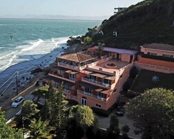Un edificio de varios pisos con balcones que dan a una playa y al océano.