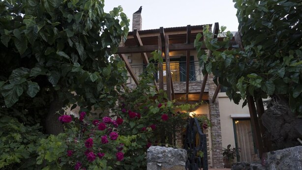 A stone staircase leading to a wooden deck with a stone wall on one side. - Elia Therissos Maisonettes (Chania)