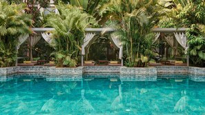 A pool surrounded by lush tropical plants and a stone-tiled edge. - Plantation Urban Resort & Spa (Phnom Penh)