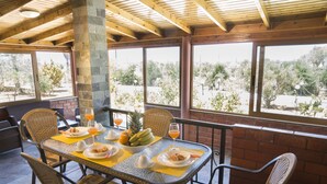 A dining area with a table set for two, featuring a fruit bowl, plates, and glasses. - Elia Stavros Villas (Chania)