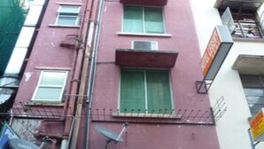 Un edificio de varios pisos con un letrero que dice 'HOTEL LEGENT' en la fachada.