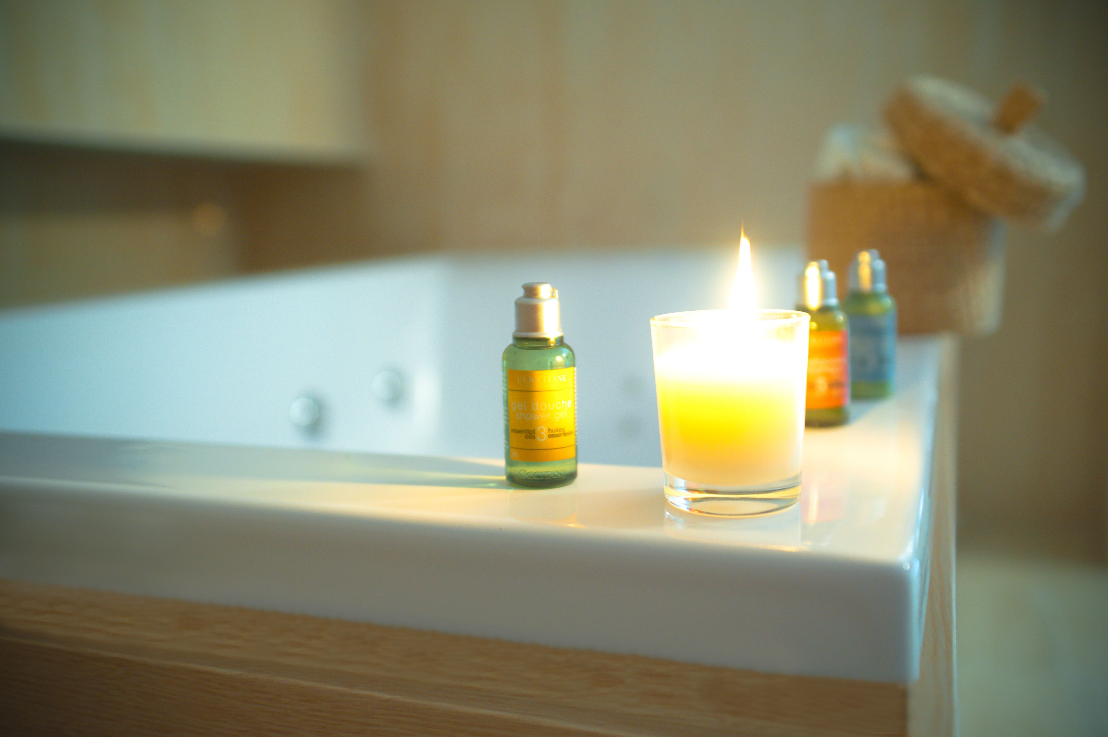 A bathtub with candles and essential oils.