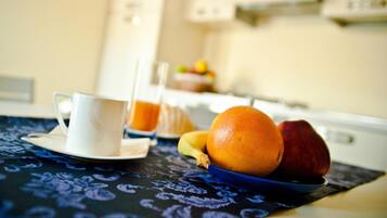 Desayuno con una taza, una naranja y un plátano sobre la mesa.