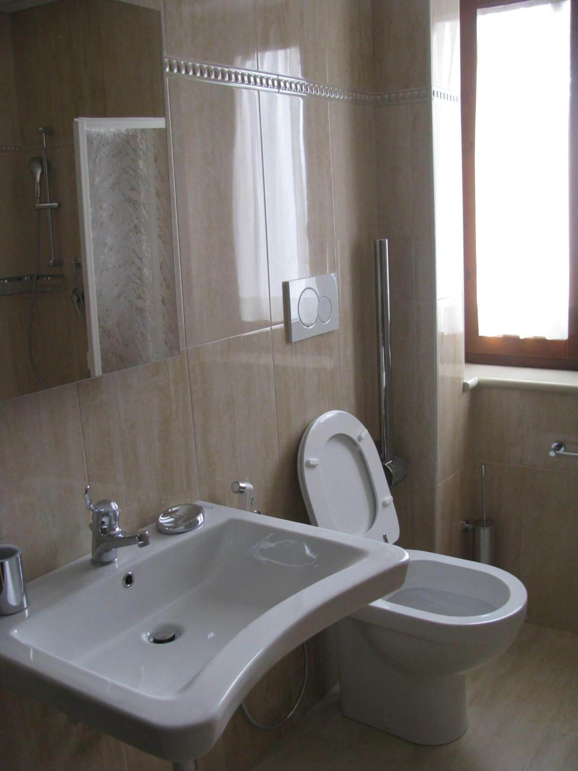 A bathroom with a sink, toilet, and shower.