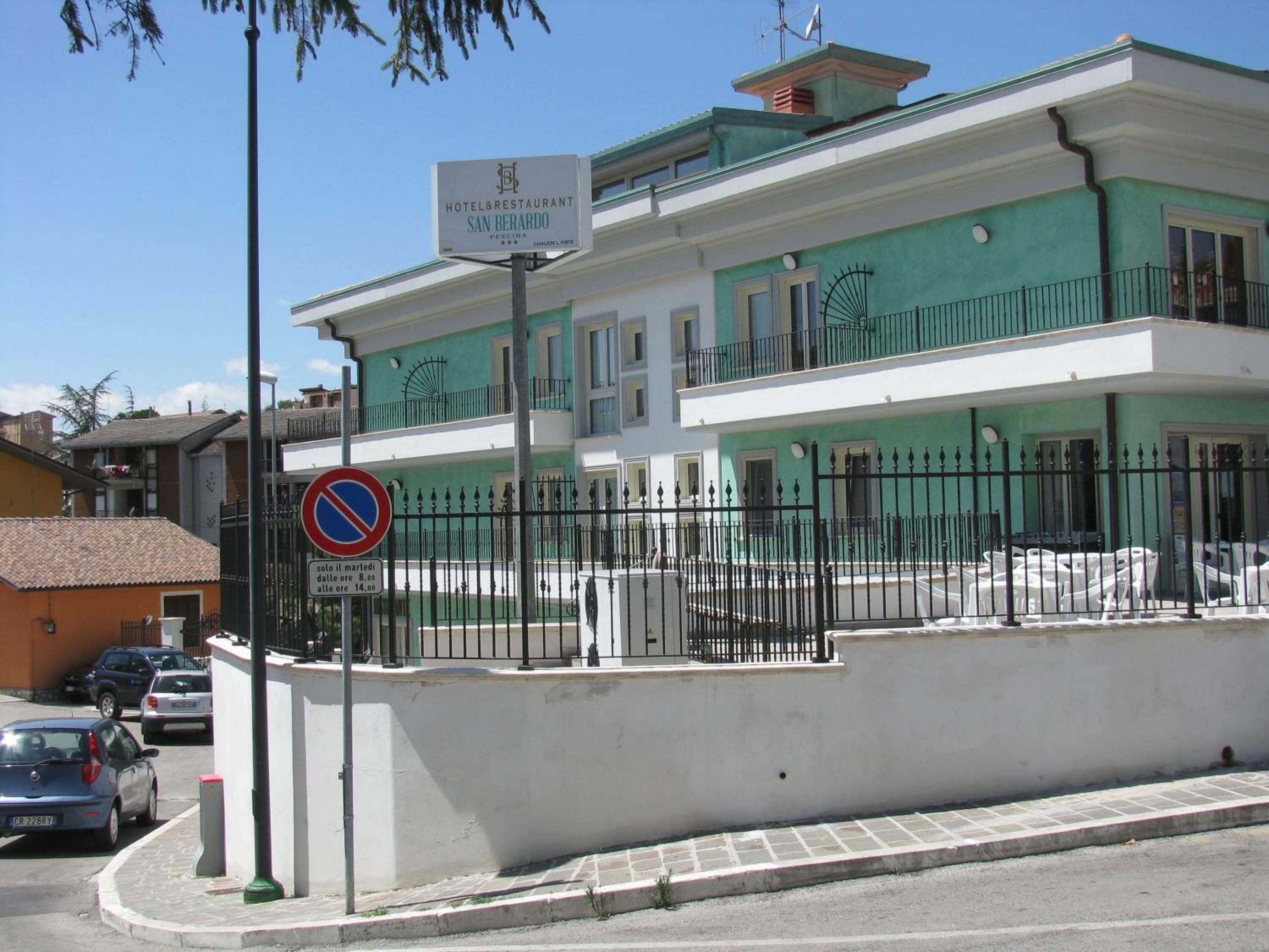 A hotel with a sign indicating it is a hotel and restaurant named San Bernardo.