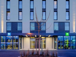 A modern building with a tree in front, glass doors, and signs for 'ibis budget' and 'ibis styles'. - ibis Styles Konstanz (Konstanz)