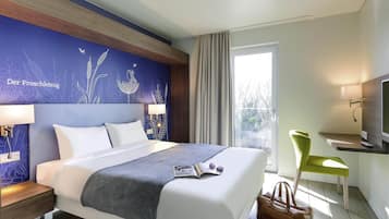 A hotel room with a bed, bedside lamps, a desk with a chair, a television, and a window with curtains.