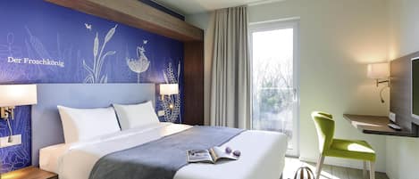 Habitación de hotel con cama, lámparas de noche, escritorio con silla, televisor y ventana con cortinas.