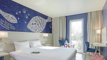 A hotel room with a large bed, a desk, a chair, and a view of the outdoors.