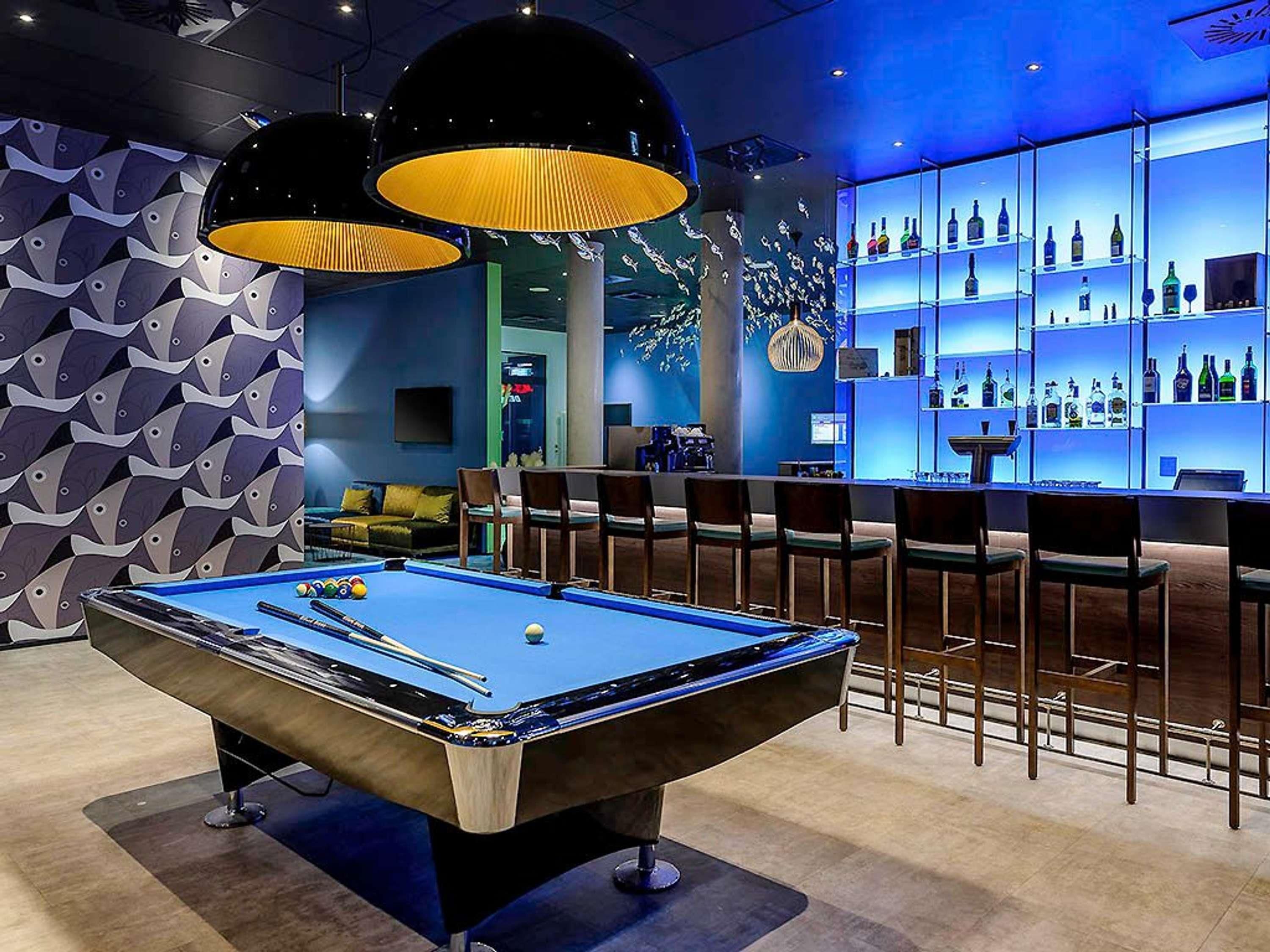 Una mesa de billar con zona de bar que incluye estantes llenos de botellas.