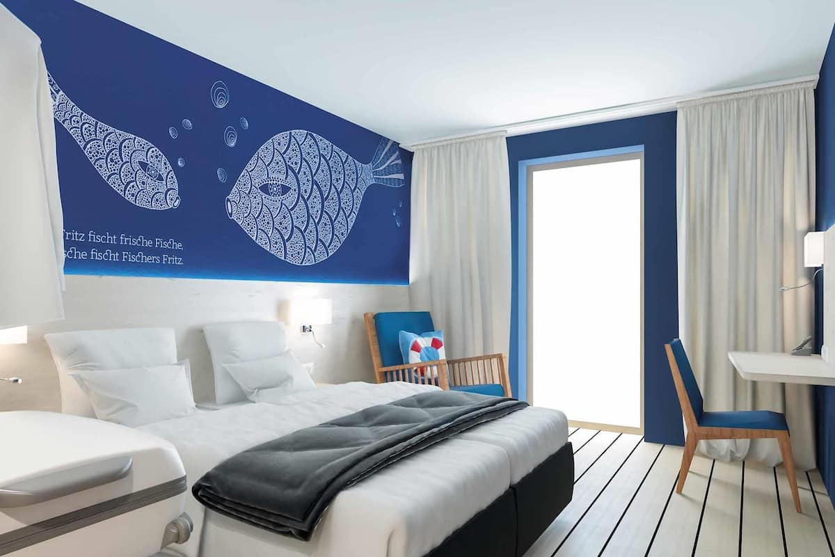 A hotel room with a bed, bedside tables, a desk, and a chair.