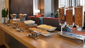 A buffet setup with various food items and serving utensils. - Embassy Suites by Hilton Chicago Naperville (Naperville)