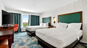 A hotel room with two beds, a desk, a chair, a TV, and a window with curtains. - Hampton Inn & Suites Chippewa Falls (Chippewa Falls)