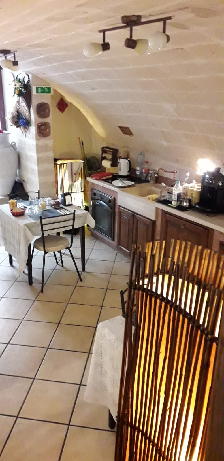 A kitchen with a dining table, chairs, a stove, and a sink.