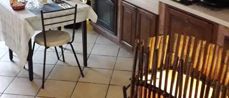 A kitchen with a dining table, chairs, a stove, and a sink.