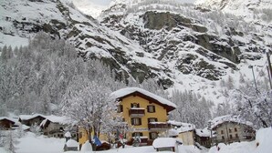 A snow-covered mountain village with a prominent yellow building labeled "Hotel Paramont." - Hotel Ristorante Paramont (Arvier)