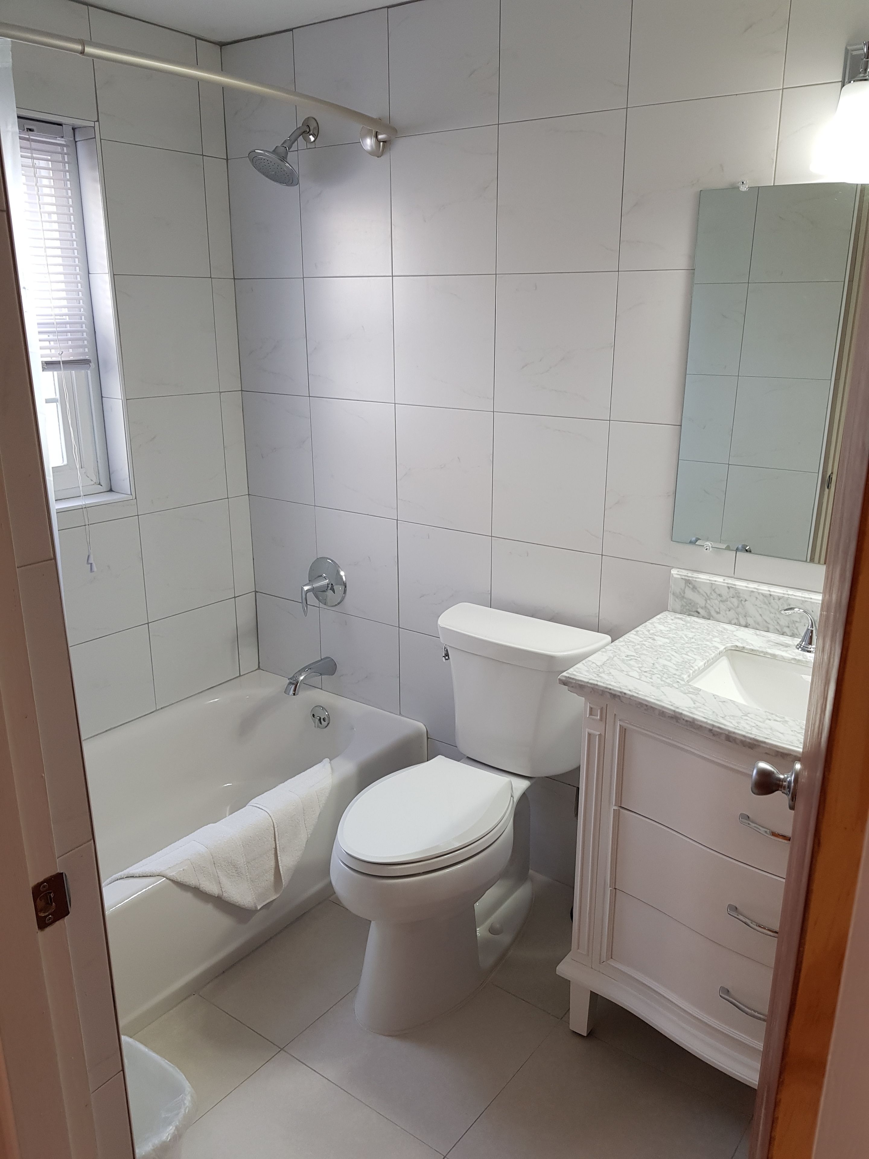 A bathroom with a bathtub, toilet, and sink.