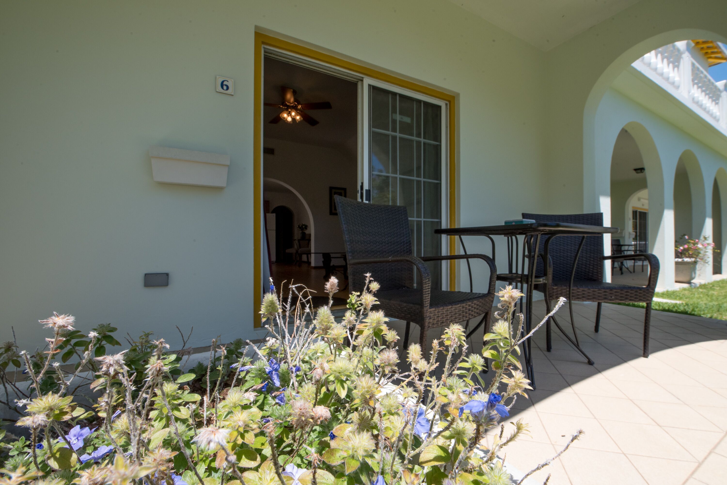 A covered patio with outdoor furniture, a sliding glass door, and a view of the interior.