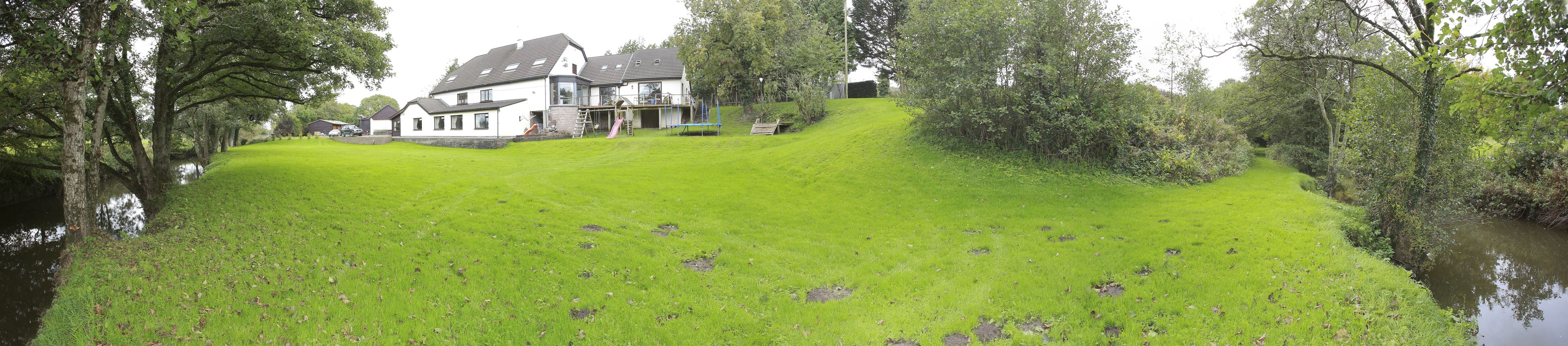 A large house with a well-maintained lawn and a small pond.