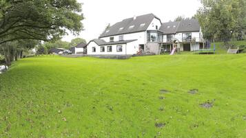 A large house with a well-maintained lawn and a small pond.
