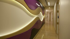 Un pasillo moderno de hotel con un diseño de pared ondulado y suelo de madera.