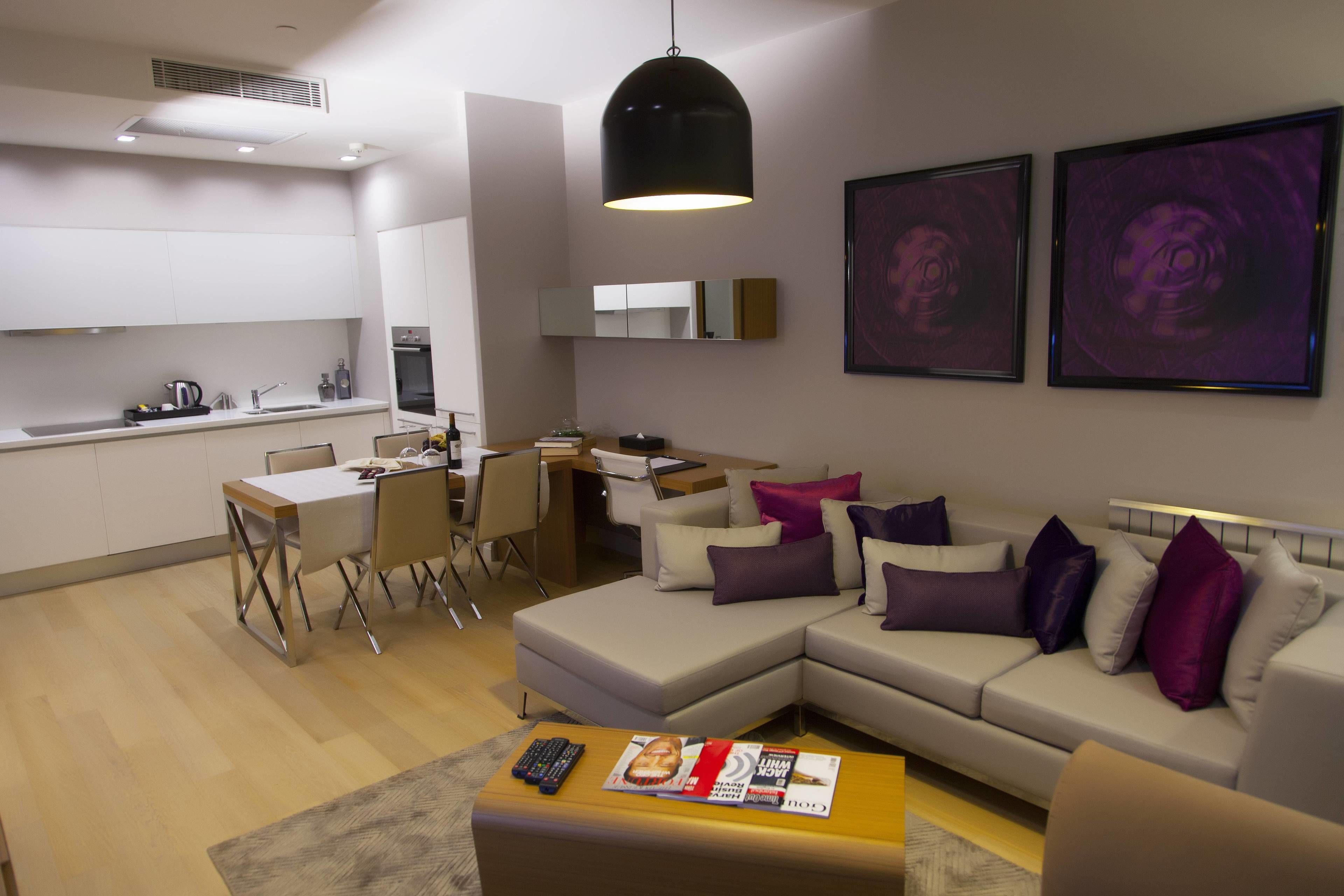 Un salon moderne comprenant un canapé, une table basse et un coin repas avec des chaises et une table.