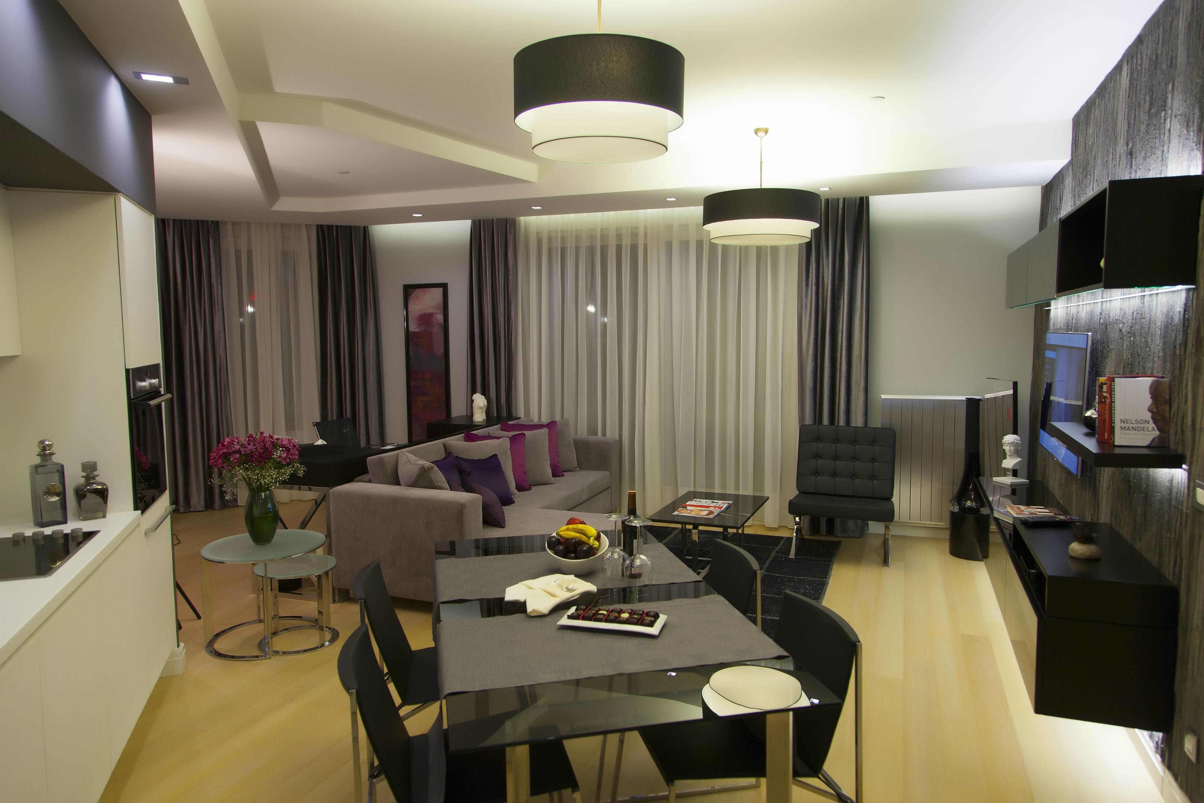 A modern living room with a dining area, a sofa set, and a TV.
