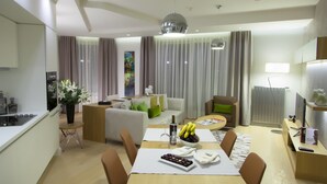 Una habitación de hotel moderna con comedor, sala de estar y cocina.