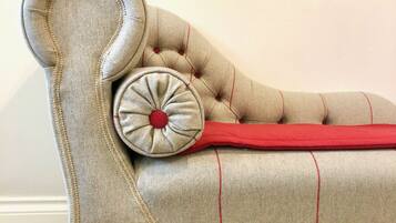 A tufted sofa with a curved backrest and a decorative pillow.