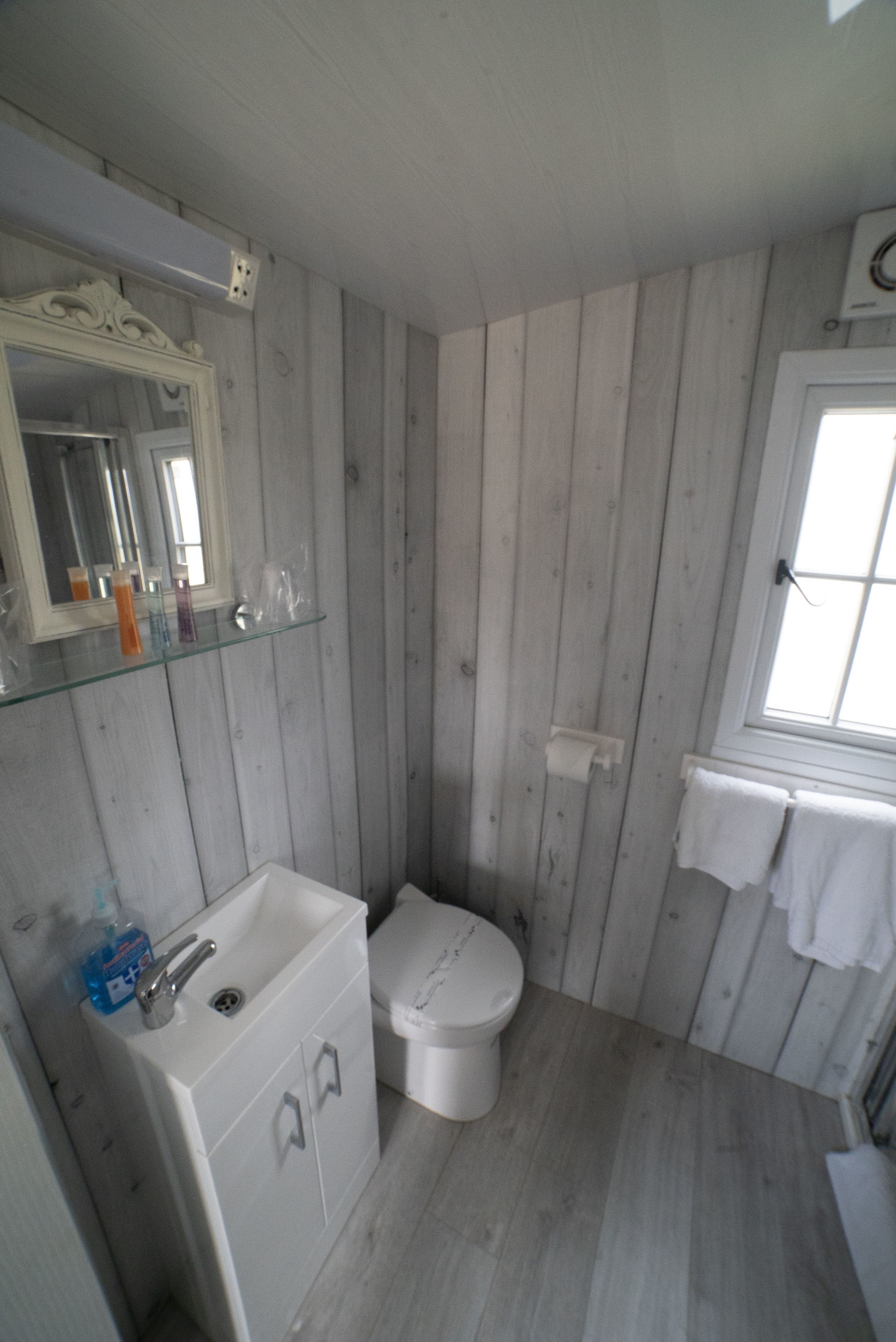 A bathroom with a white sink, toilet, and mirror.