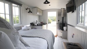 Un dormitorio con una cama grande, una mesita de noche, un escritorio y una ventana.