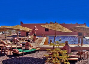 Alberca al aire libre y camastros 