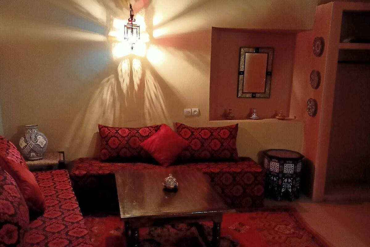A cozy living room with a patterned sofa, a coffee table, and a decorative lamp.