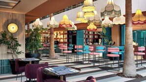 A modern indoor space with striped flooring, round tables with purple chairs, and colorful hanging lamps. - BH Mallorca Apartments - Adults Only (Calvia)