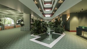 A spacious indoor atrium with a central water feature, geometric patterned flooring, and a modern ceiling design. - BH Mallorca Apartments - Adults Only (Calvia)