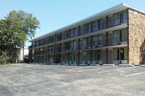 Ein zweistöckiges Motel mit Parkplatz davor.