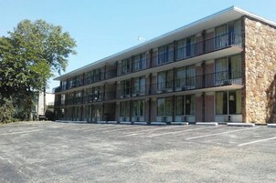A two-story motel with a parking lot in front.